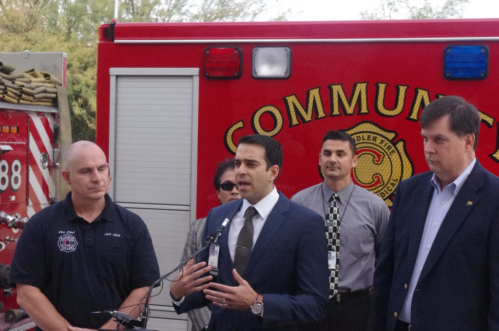 Chandler Fire-Medical Chief Jeff Clark, left, listens as Dr. Hamed Abbaszadegan of the Veterans Administration describes the new Community Involvement and Intervention Project, an initiative encouraged by the former Chandler Councilmember Bob Robson, right.