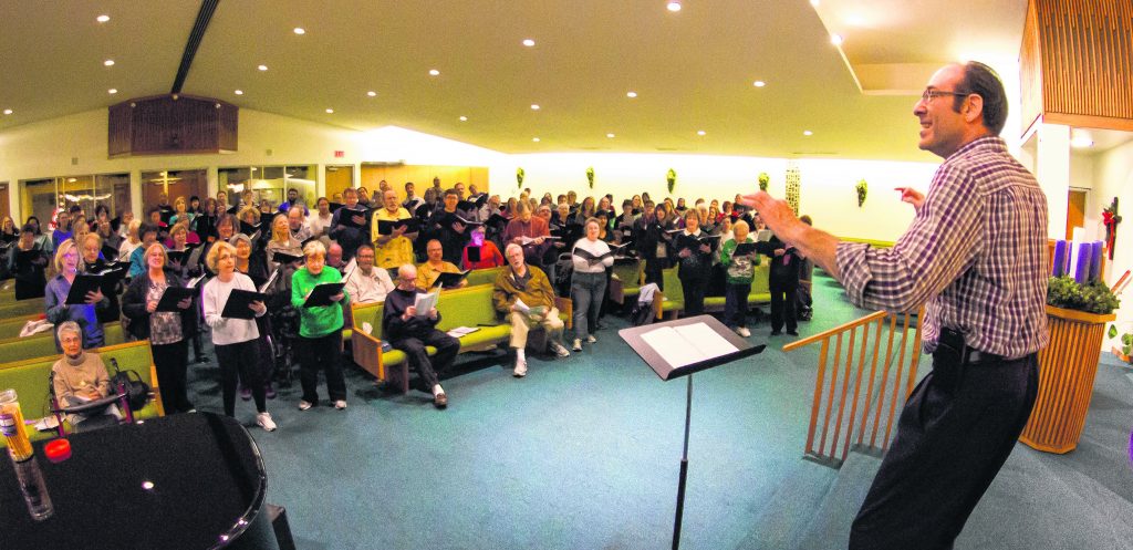 Director Cary Burns provides inspiration to 129 members of Tempe Community Chorus during a practice session at University Presbyterian Church in Tempe. The group will have a holiday concert Dec. 20 at the Mesa Arts Center. (Alex Walker/WRANGLER NEWS PHOTO)