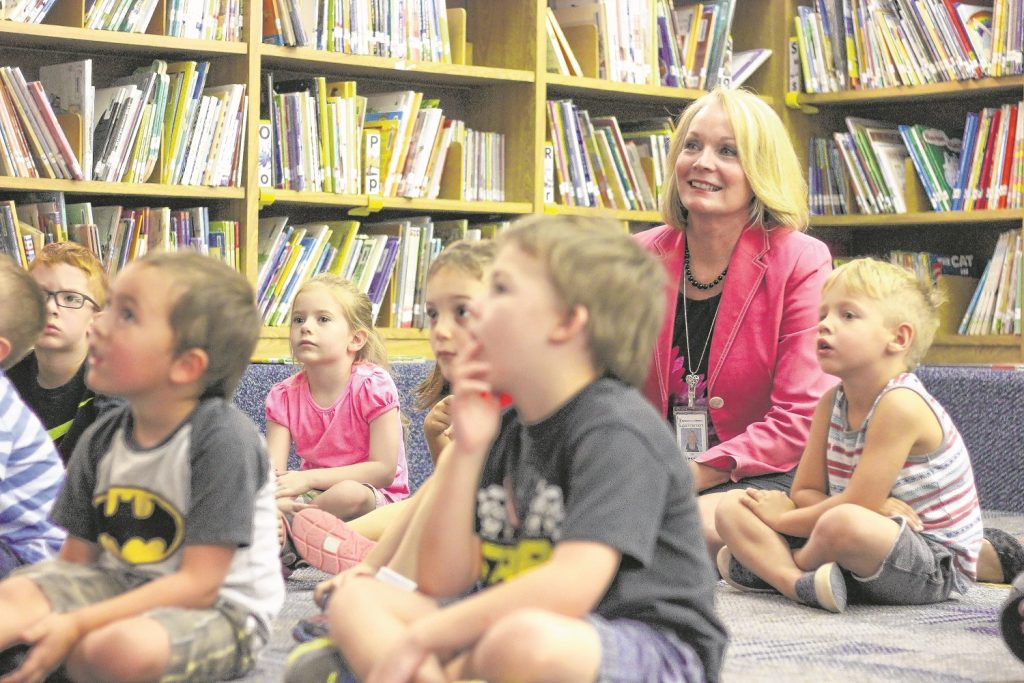 Kyrene Superintendent Jan Vesely relaxes alongside students taking in story time at Waggoner Elementary's library, where Summer Academy is in full swing.                                          — Wrangler News photo by Alex J. Walker           